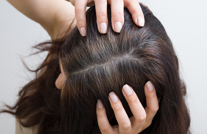 Junge Frau mit vorzeitigen, einzelnen grauen Haaren